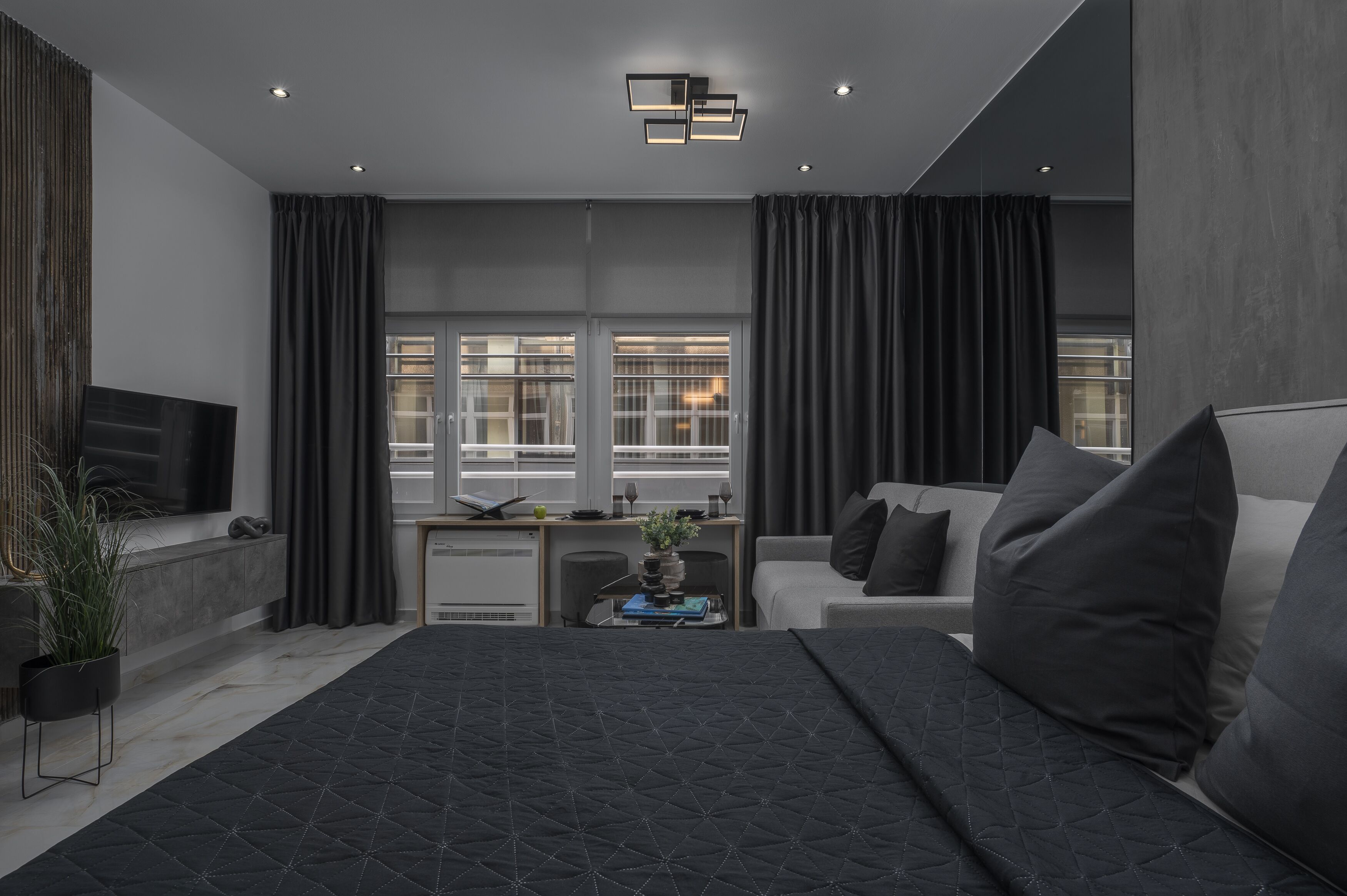 Ein modernes Schlafzimmer mit einem großen Bett, einem Schreibtisch und einer Couch.