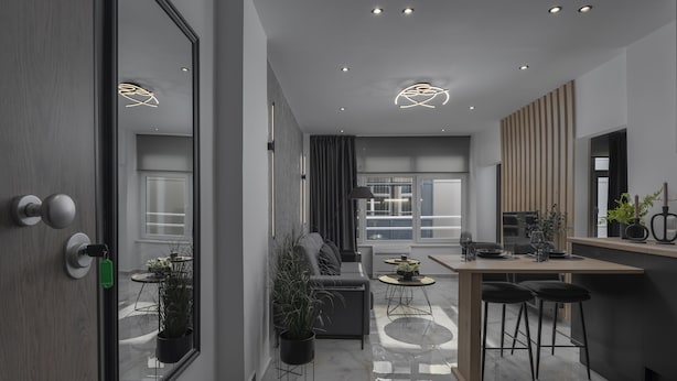 Een moderne woonkamer met een bank, salontafel en potplanten.