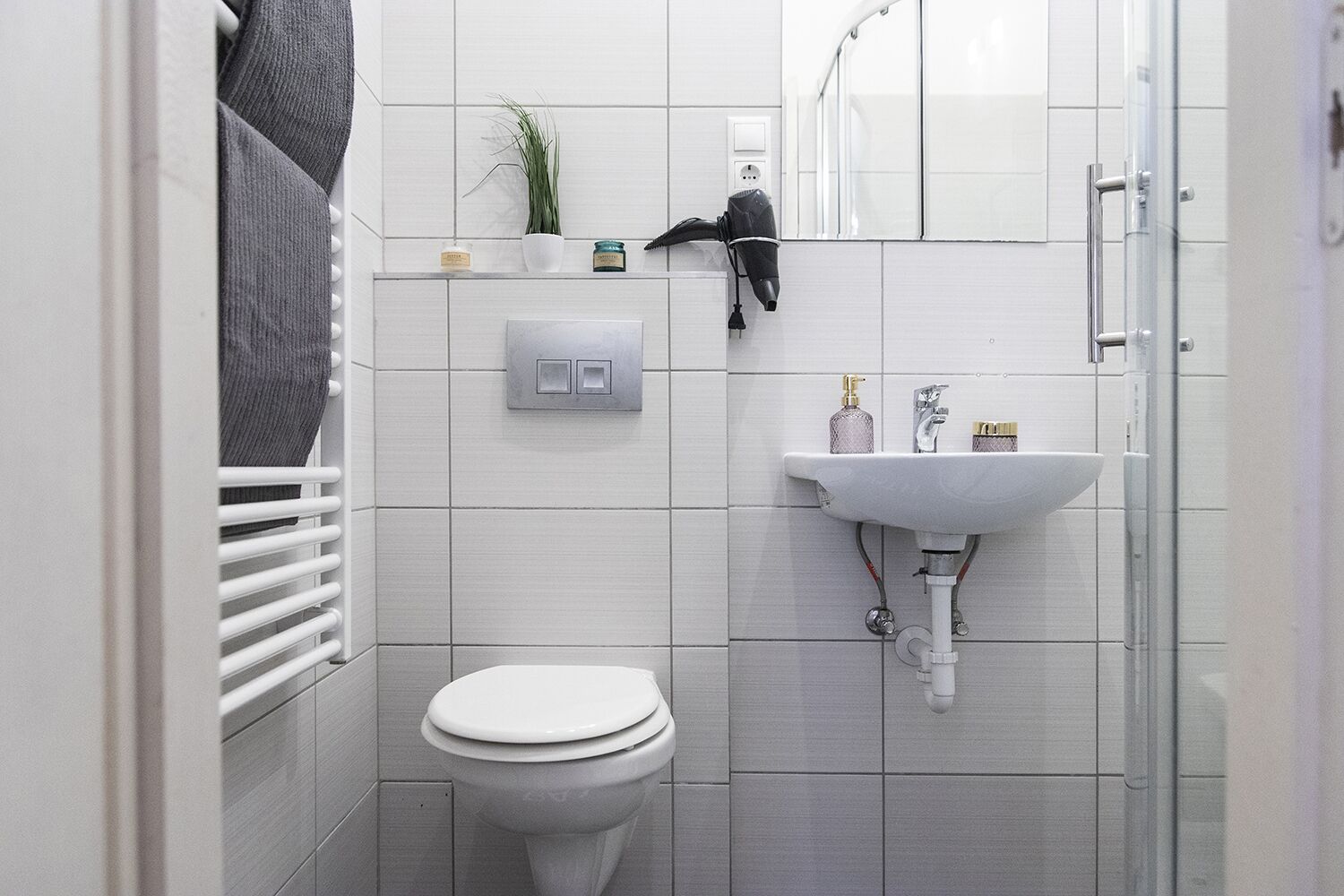 A modern bathroom with a toilet, a sink, and a shower.