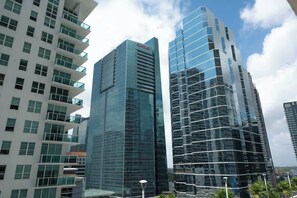 A modern high-rise building with a glass facade and a prominent logo on the top. - 2BR Heart of Brickell W/ Pool, Hot Tub, and Gym! (Miami)