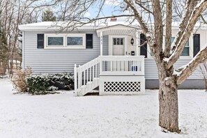 A single-story mobile home with a white exterior, a front porch with a railing, and a small front yard. - Boho Chic Work Escape - 2-Bedroom, Close to Burlington/Airport (South Burlington)