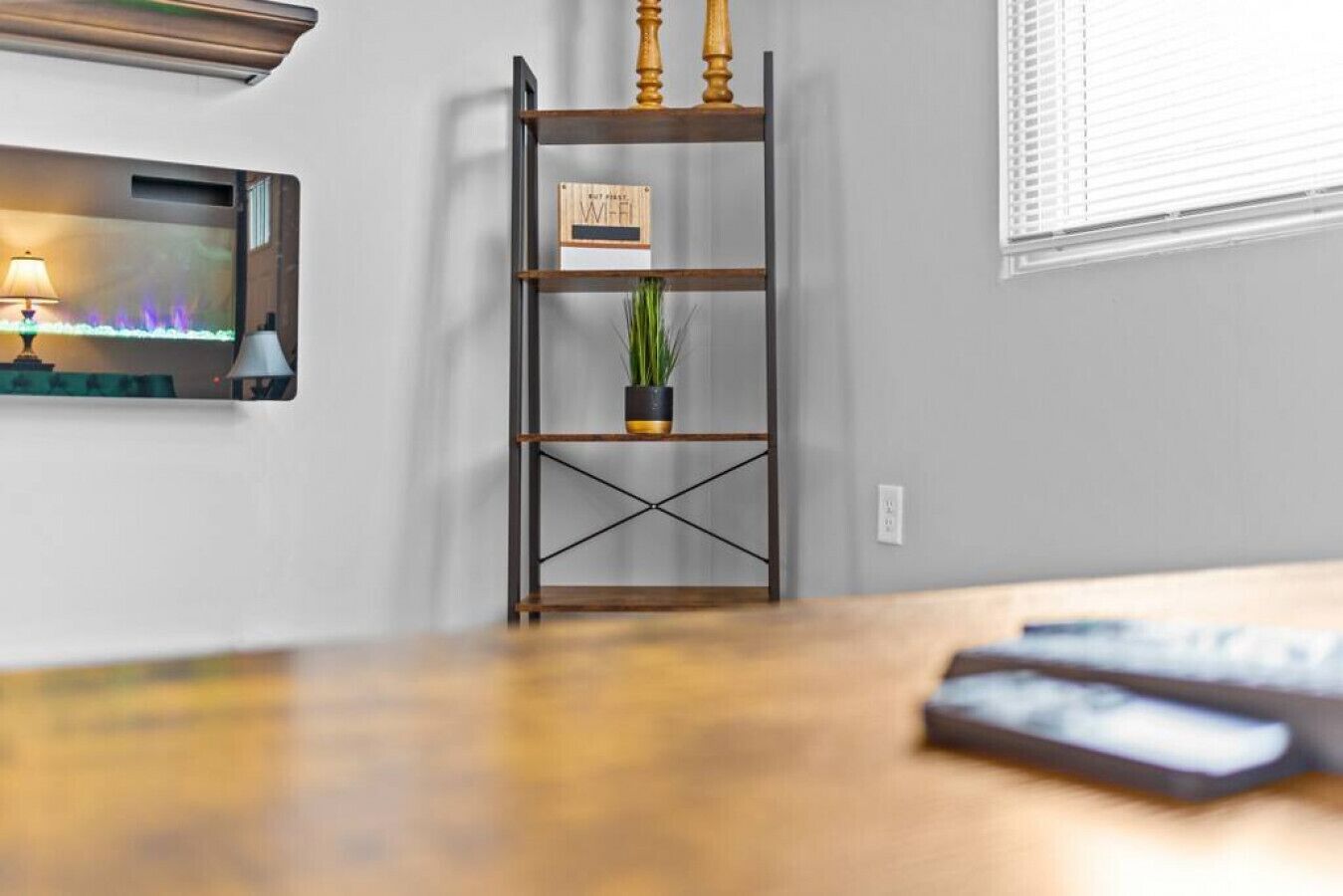 A wooden desk with a plant on a metal shelf, a lamp, and a sign indicating Wi-Fi availability.