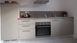 A modern kitchen with a stainless steel range hood, a built-in oven, and a sink. - Flat with terrace, quiet and sunny,2 bike, air cond,bike storage (Riva del Garda)
