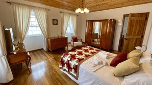 A wooden-paneled bedroom with a bed, dresser, and wardrobe. - Casa do Avô José Alves (T3), Country House - Rural Tourism  (Cabo da Praia)