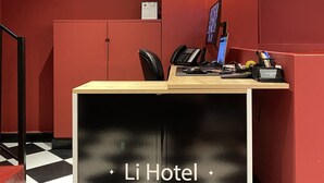 A reception desk at Li Hotel in Pera with a black and white checkered floor, a security camera, a framed certificate, and a calendar on the wall. - Li Hotel Pera (Istanbul)