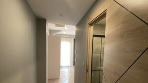 A hallway with a wooden wardrobe, a door, and a light fixture on the ceiling. - Li Hotel Pera (Istanbul)
