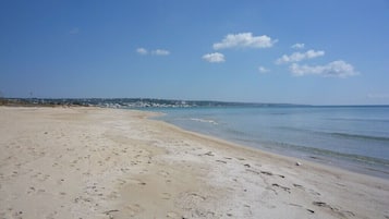 Una playa cerca, sillas reclinables de playa, toallas de playa