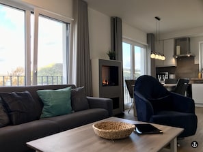 A modern living room with a sofa, a coffee table, and a view of the outdoors. - Sonnenweg 1 (Diemelsee)