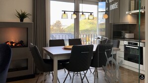 A modern kitchen with a dining area, a fireplace, and a view of the outdoors. - Sonnenweg 1 (Diemelsee)
