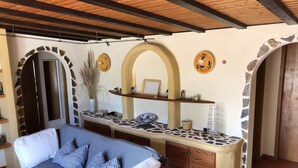 Une pièce chaleureuse avec un canapé, une petite table et une arche en pierre.