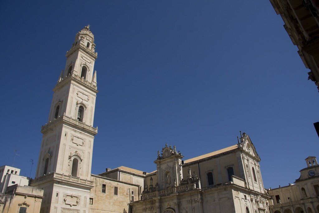 A historic building with a prominent clock tower and a smaller adjacent structure.