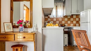 A kitchen with a wooden counter, a sink, a refrigerator, and a chair. - Holiday Home 'Garden House Lefkada' with Shared Terrace, Wi-Fi and Air Conditioning (Lefkada)