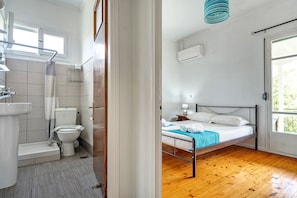 A bathroom with a toilet, sink, and shower area.