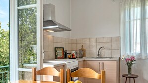Een keuken met een raam, een fornuis en een spoelbak.