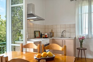 A kitchen with a window, a stove, and a sink.