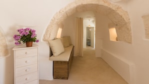 A narrow hallway with a stone archway, a bench, a dresser, and a potted plant. - "Villa Filara" with Private Pool, Private Terraces & Wi-Fi (carovigno)