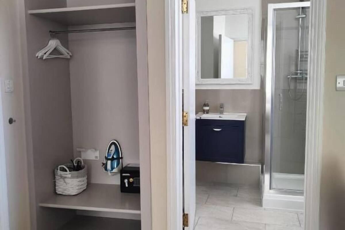 Un armario con estantes, una barra para colgar ropa y una cesta de almacenamiento.