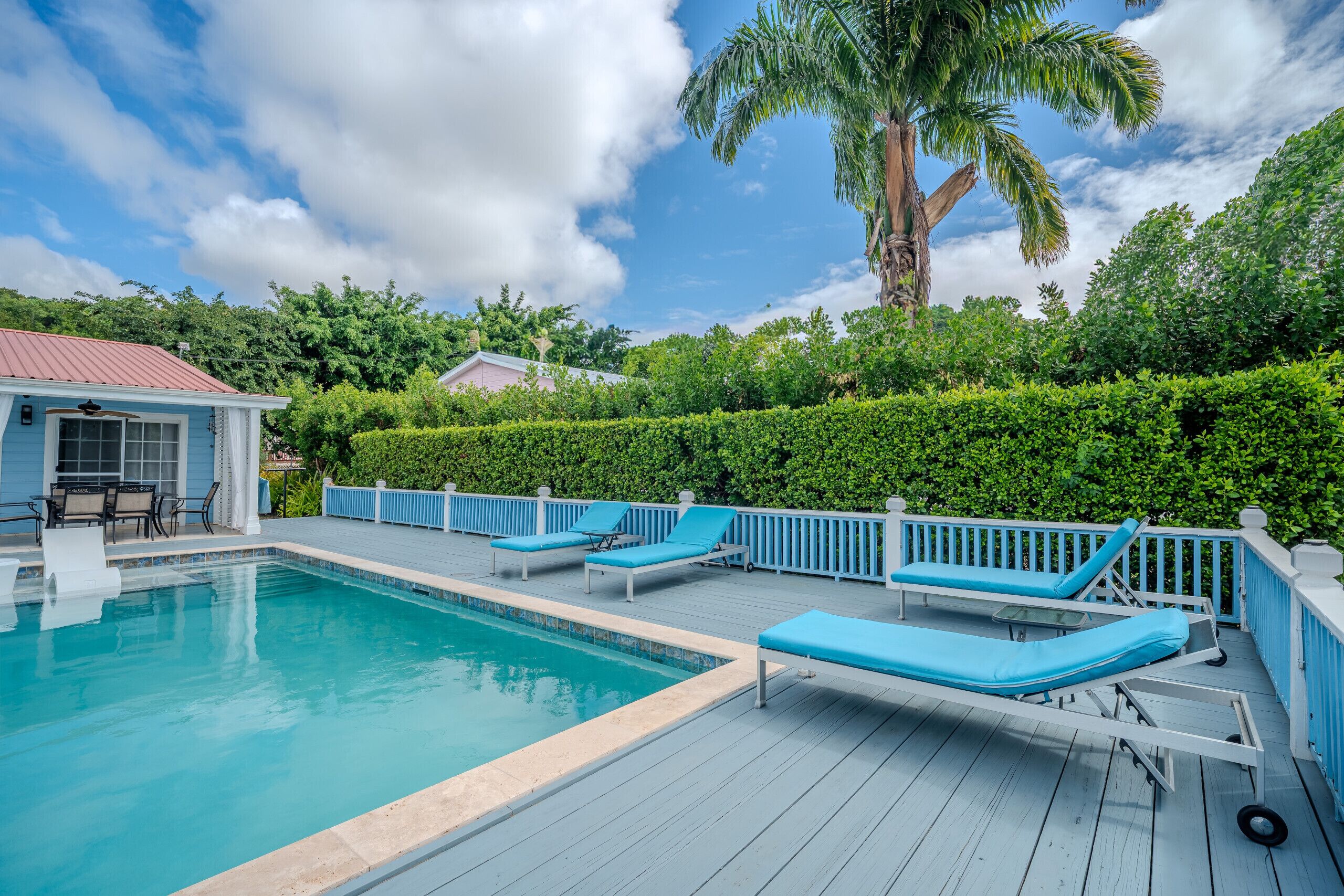 A pool with lounge chairs and a deck.