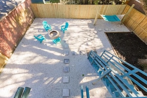 Un jardin avec un foyer, des sièges d’extérieur et un hamac.