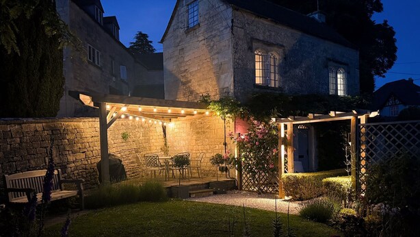 A stone building with a covered patio area, outdoor seating, and string lights. - Rose Cottage, Rodborough - sleeps 6 guests  in 3 bedrooms (Stroud)