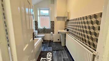 Une petite salle de bain comprenant des toilettes, un lavabo et un radiateur.