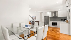 A modern kitchen with white cabinetry, a stainless steel refrigerator, and a microwave. - Thompson's Retreat in Cowes (Cowes)
