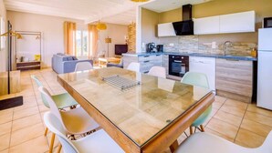 A modern kitchen with white cabinets, a black range hood, and a built-in oven. - Le Grand Cottage Nature Piscine Chauffée Privée (Peyrole)