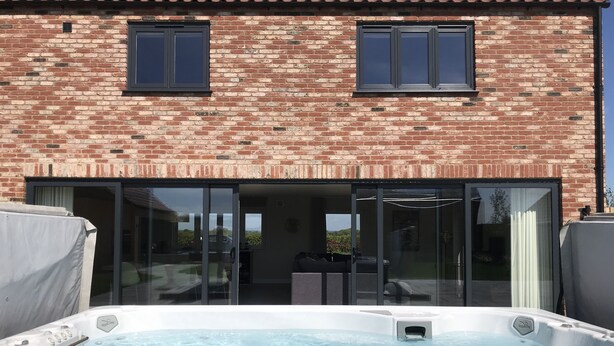 Une maison en briques avec une porte en verre donnant sur un patio.