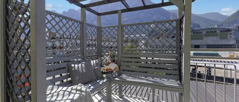 A covered outdoor seating area with a view of mountains.