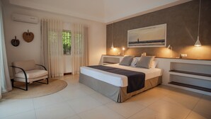 Une chambre à coucher avec un lit, une chaise, une fenêtre avec des rideaux et un tableau au mur.