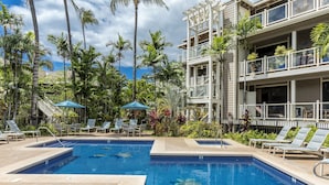A swimming pool with lounge chairs and umbrellas, surrounded by palm trees and a multi-story building. - Grand Champions #86 Gorgeous Views On Golf Course, Near Popular Beaches (Wailea)