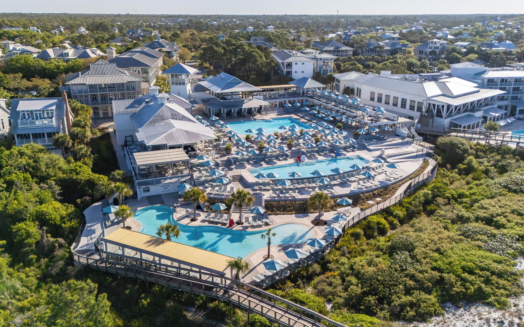 A resort with multiple swimming pools, lounge areas, and a variety of buildings.