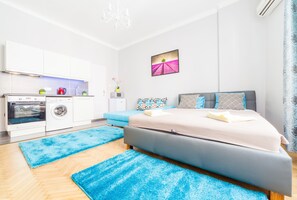 Un dormitorio moderno con cama, mesita de noche, cortinas y vistas al exterior.
