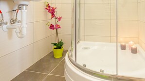A modern bathroom with a glass-enclosed shower, a white sink, and a bathtub. - Real Apartments Wesselényi III.  (Budapest)