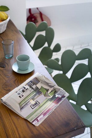 A wooden table with a blue cup and saucer, a glass, and a magazine. - Iommella luxury rooms (Sant'Agnello)