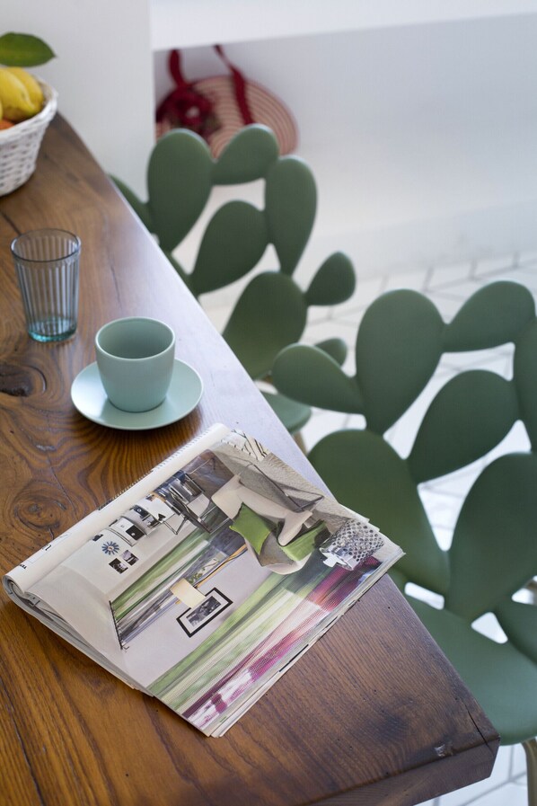 Une table en bois avec une tasse et une soucoupe bleues, un verre et un magazine.