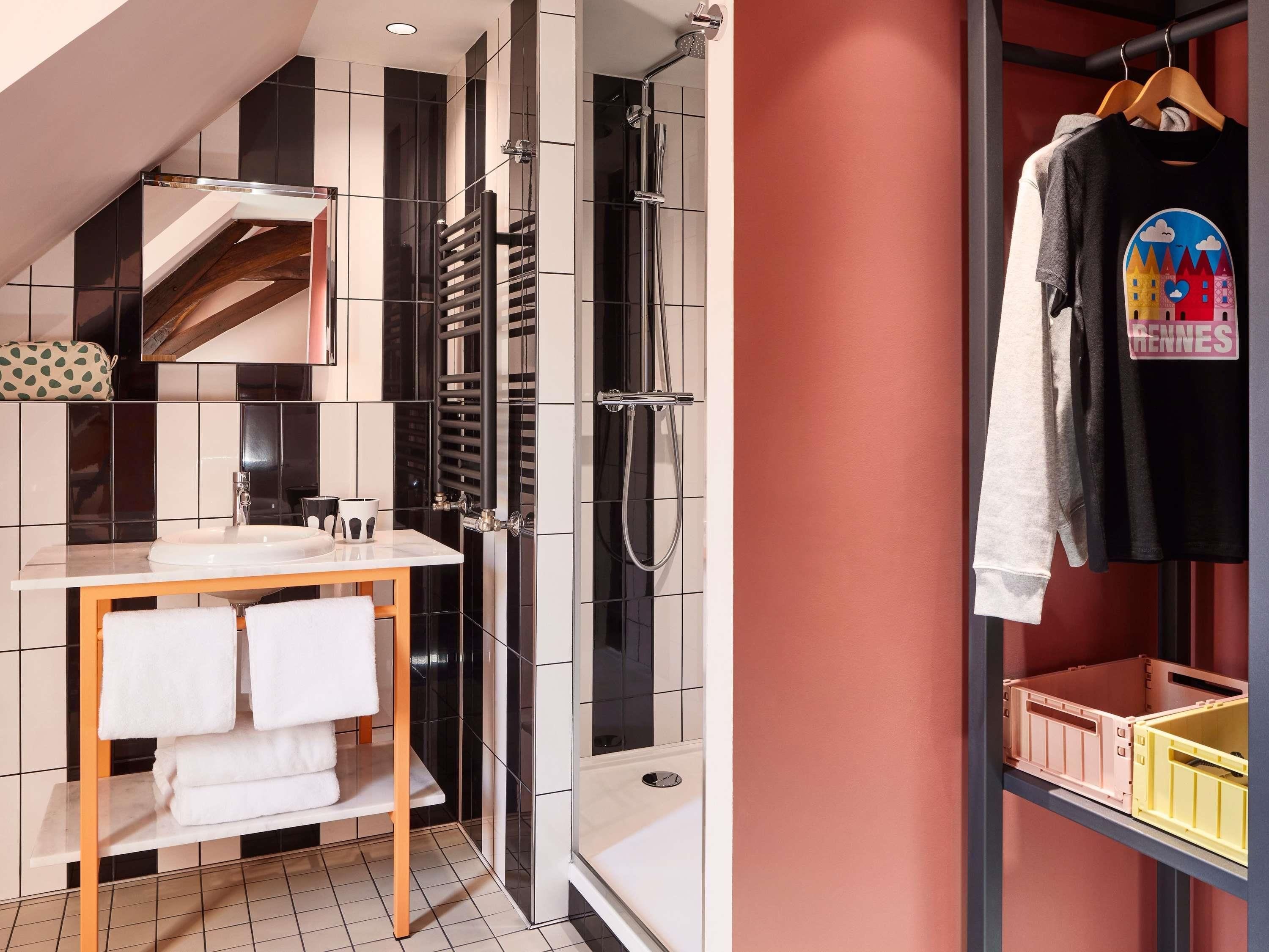 Une salle de bain moderne équipée d’une douche, d’un lavabo et d’un porte-serviettes.