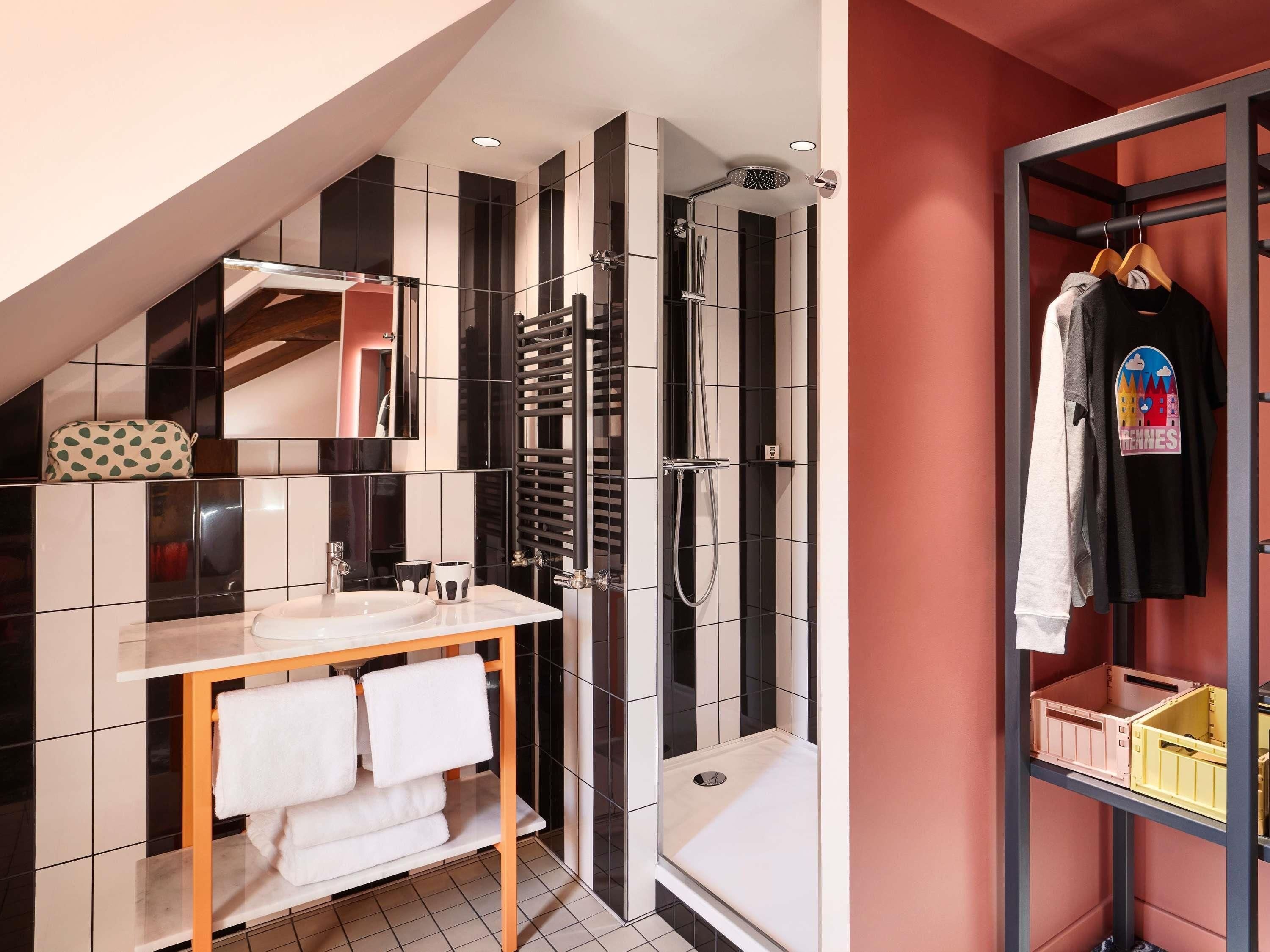 A modern bathroom with a shower, a vanity with a sink, and a towel rack.