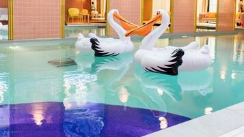 A swimming pool with two swan-shaped inflatable floats.