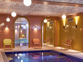 Una piscina techada, sillones reclinables de piscina