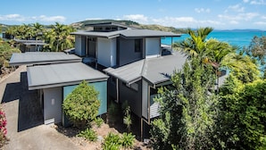 A modern coastal property with multiple units, each featuring a balcony and a view of the sea.
