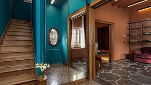 A staircase leading to a room with a teal wall, a wooden door, and a glass partition. - Dimora San Trovaso (Venice)
