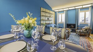 A dining area with a blue wall, a fireplace, and a view of the city. - Dimora San Trovaso (Venice)