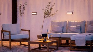 Een gezellige zithoek met een bank en stoelen, een bijzettafeltje en decoratieve planten.