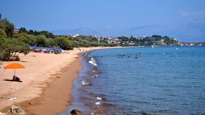 Una spiaggia con una riva sabbiosa, alcuni ombrelloni e un mare cristallino.
