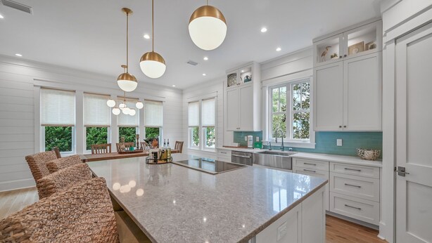 A spacious kitchen with a large island, white cabinetry, and pendant lighting. - Clubhouse Amenities and 6-Seat LSV (Santa Rosa Beach)