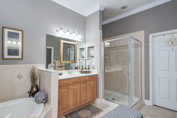 A modern bathroom with a bathtub, vanity, and walk-in shower.