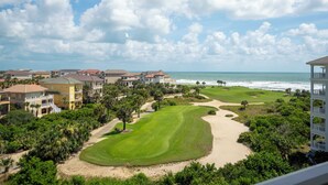 A golf course with a sandy beach, ocean view, and residential buildings in the background. - Top Floor Penthouse Oceanview Corner Unit 261 - Incredible Views! (Palm Coast)