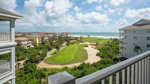 Um campo de golfe com vista para o oceano e propriedades à beira-mar.