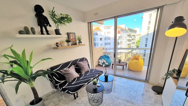 Una sala de estar moderna con sofá, mesa de centro y plantas en macetas.